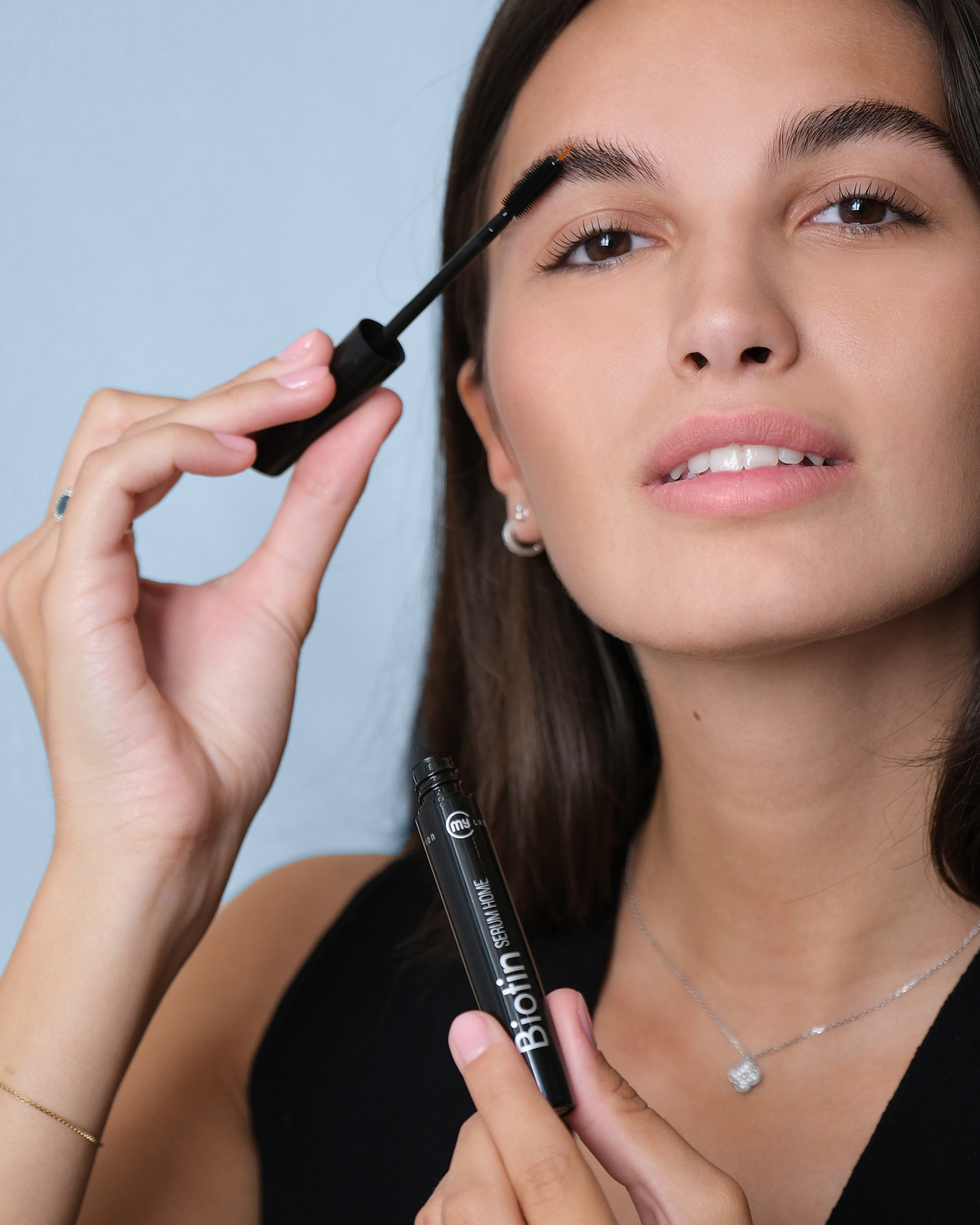 Donna che si mette il mascara vestita di nero