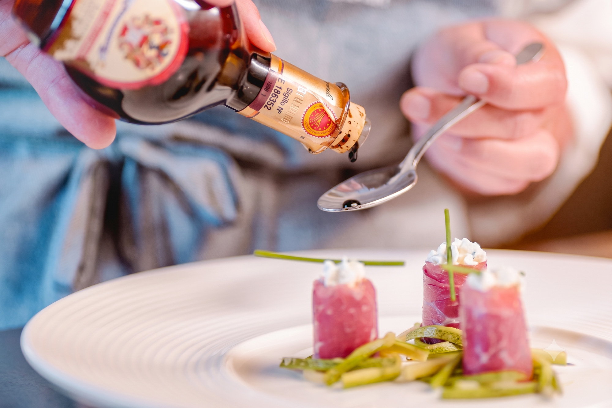 Aceto balsamico versato su cucchiaino e sul piatto
